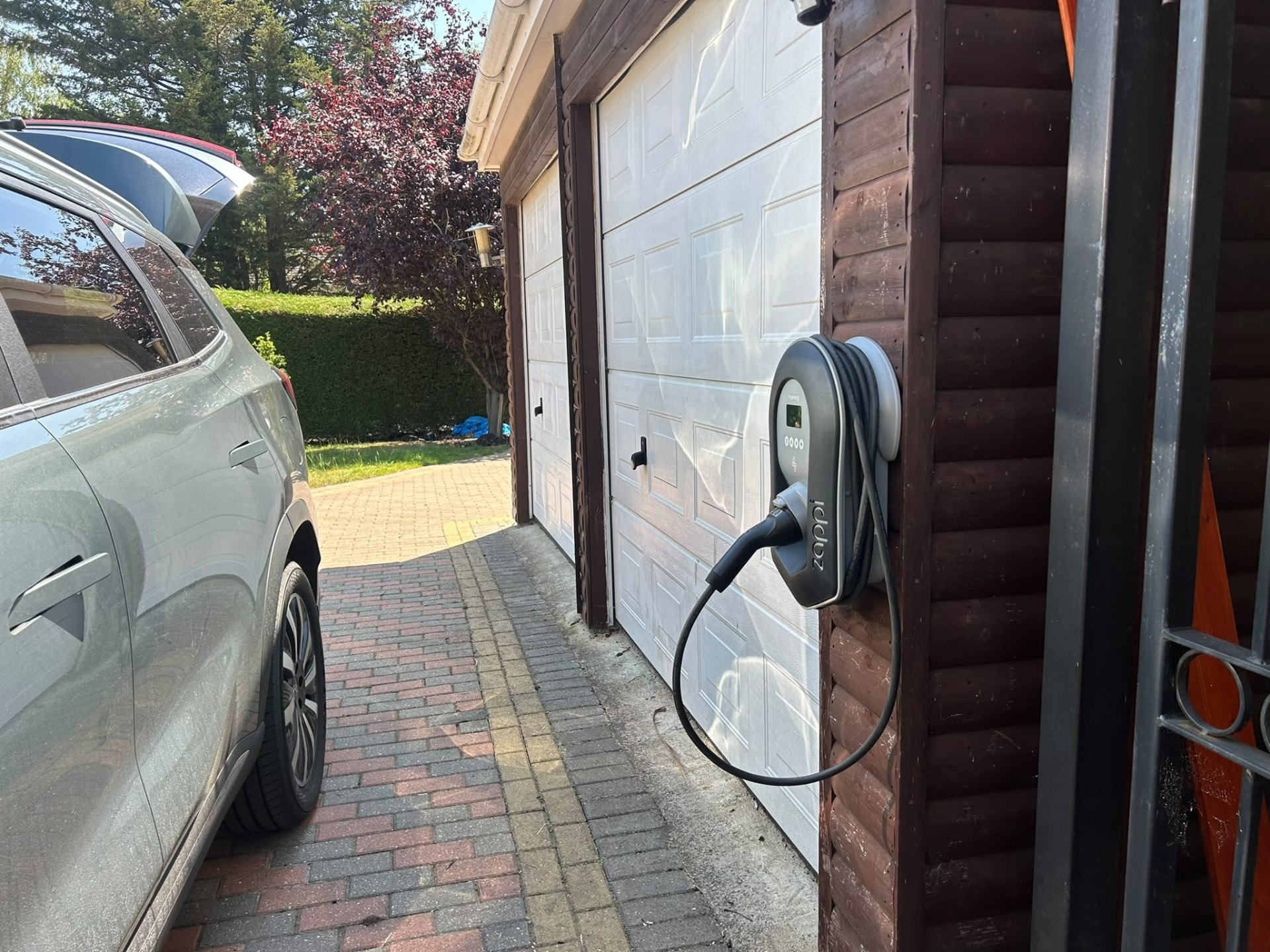 Zappi EV charger installed beside a double garage on a Winchester driveway