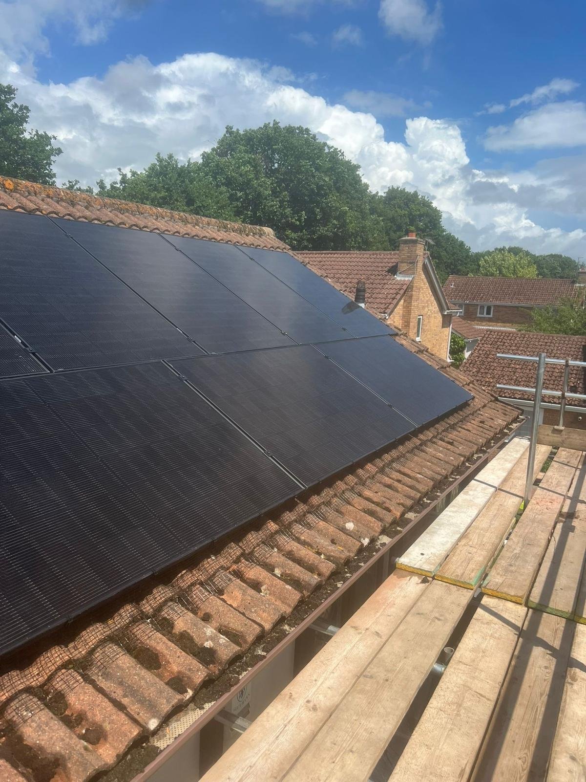 Rooftop solar installation with scaffolding overlooking Winchester rooftops