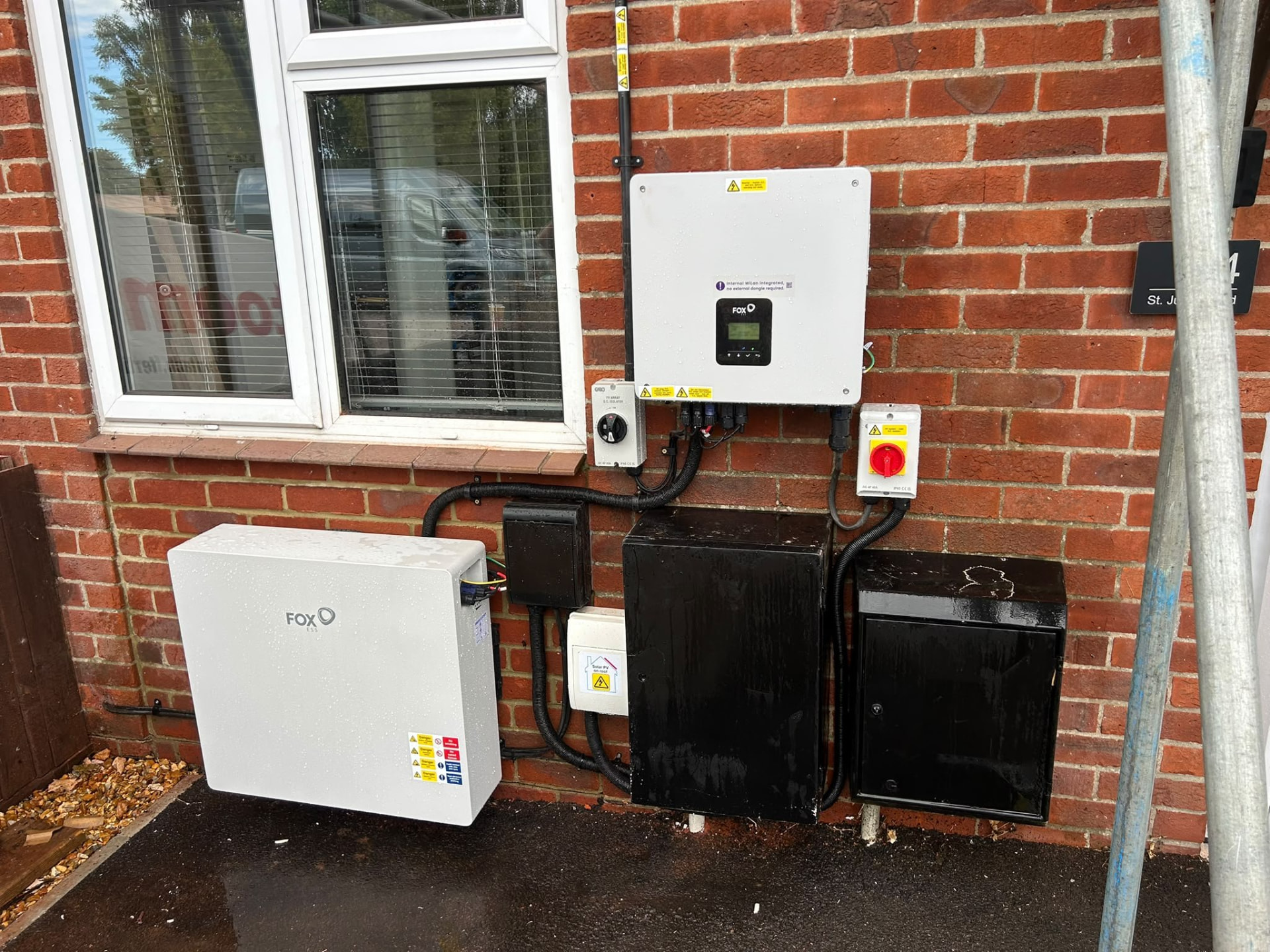 Fox ESS battery system with isolators and enclosures on a brick wall