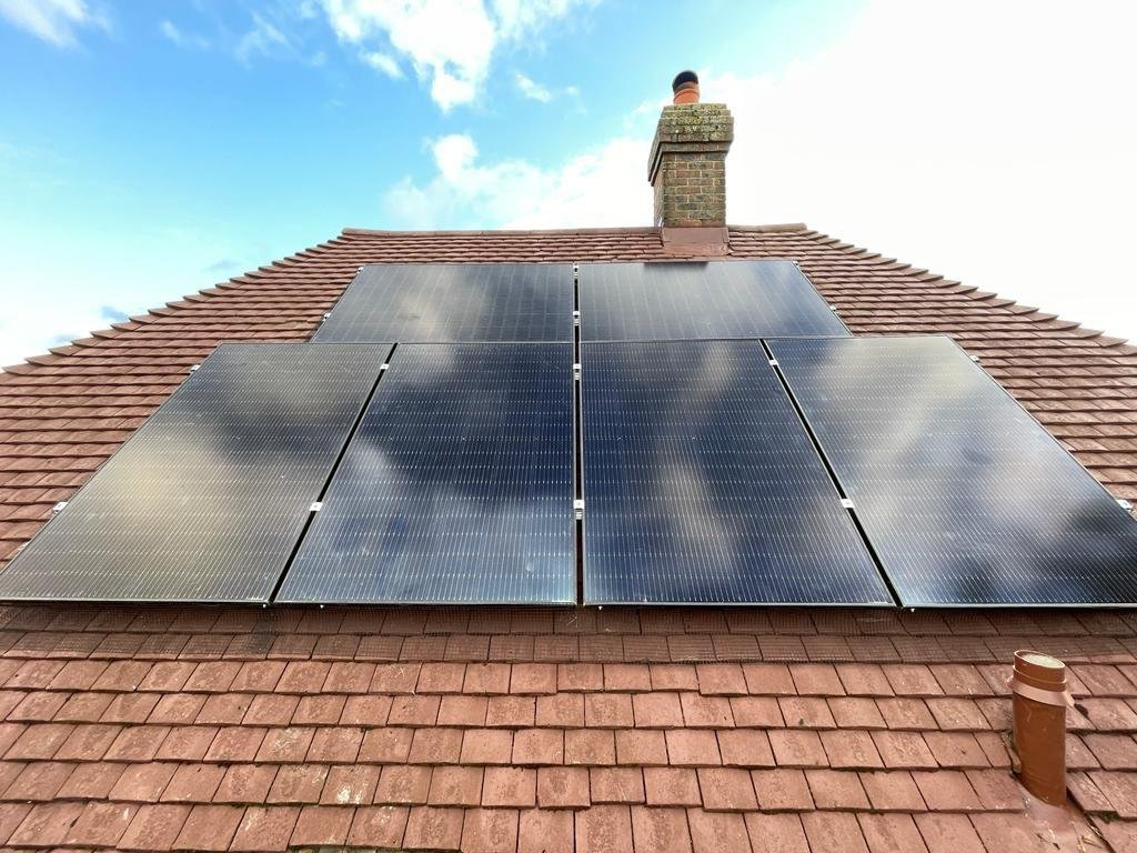 Solar PV array fitted below the chimney on a Hampshire tiled roof