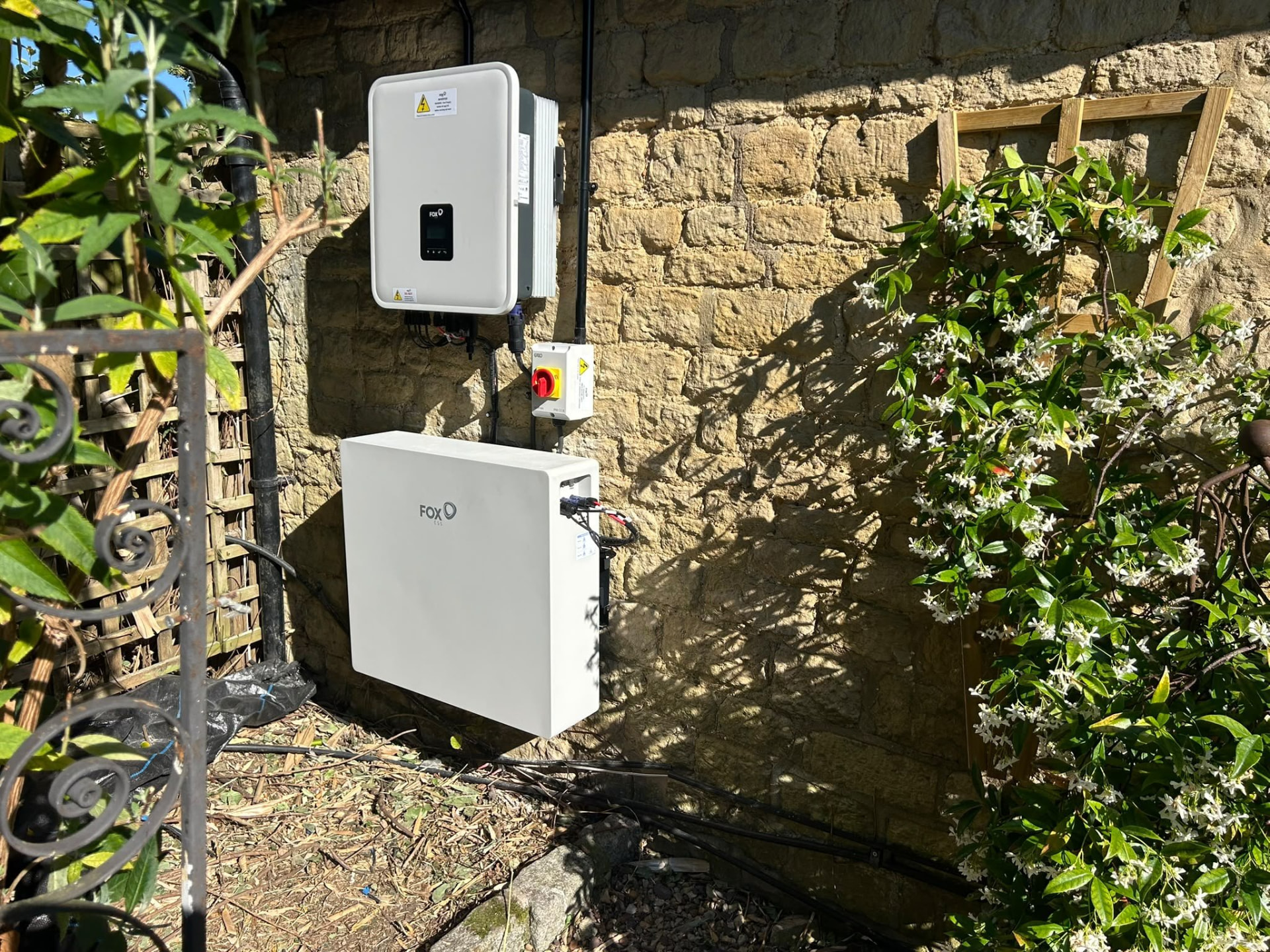 Fox ESS home battery storage installed on an exterior stone wall